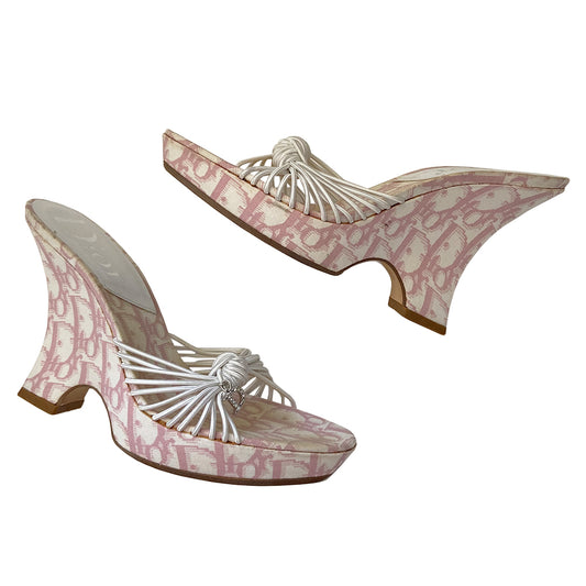 Christian Dior pink monogram canvas Girly wedge slide sandals by John Galliano for Dior circa 2003.  1” platform with curved wedge heels and leather soles. Pink monogram insole with white leather Dior logo heel pad. Multiple white elastic cord strap upper gathered with top knot accent with crystal D logo charm. Made in Italy 