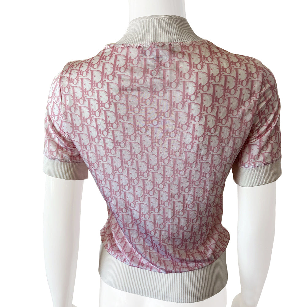 Christian Dior pink Diorissimo No. 1 short sleeve zip sweater circa 2004 by John Galliano for Dior. Front zip Diorissimo print silky feel top with with wide accent ribbing at neckline, arm hems and bottom hem. No. 1 surrounded with white crystals at upper chest. Excellent condition. Made in France 