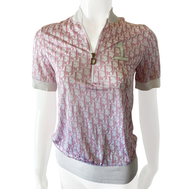 Christian Dior pink Diorissimo No. 1 short sleeve zip sweater circa 2004 by John Galliano for Dior. Front zip Diorissimo print silky feel top with with wide accent ribbing at neckline, arm hems and bottom hem. No. 1 surrounded with white crystals at upper chest. Excellent condition. Made in France 