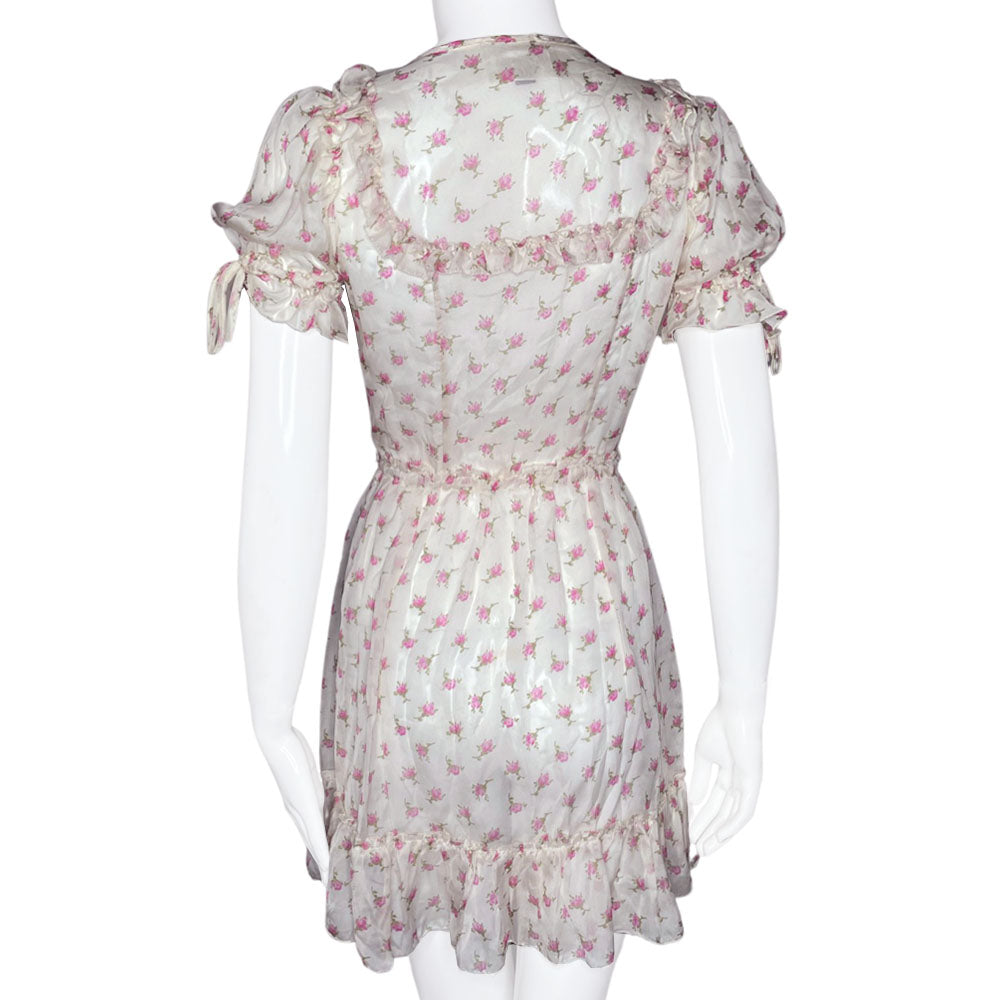 D&G silk pink and white puffed sleeve dress with D&G logo stamped button front in all over pink rosebud print. Ruffled yoke in front, back and hemline, elastic and ties at sleeves and waist. Made in Morocco 