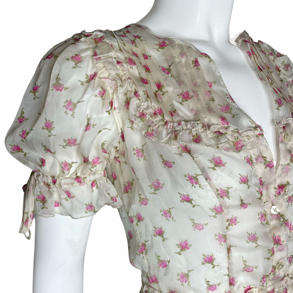 D&G silk pink and white puffed sleeve dress with D&G logo stamped button front in all over pink rosebud print. Ruffled yoke in front, back and hemline, elastic and ties at sleeves and waist. Made in Morocco 