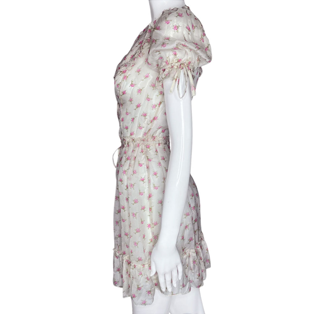 D&G silk pink and white puffed sleeve dress with D&G logo stamped button front in all over pink rosebud print. Ruffled yoke in front, back and hemline, elastic and ties at sleeves and waist. Made in Morocco 