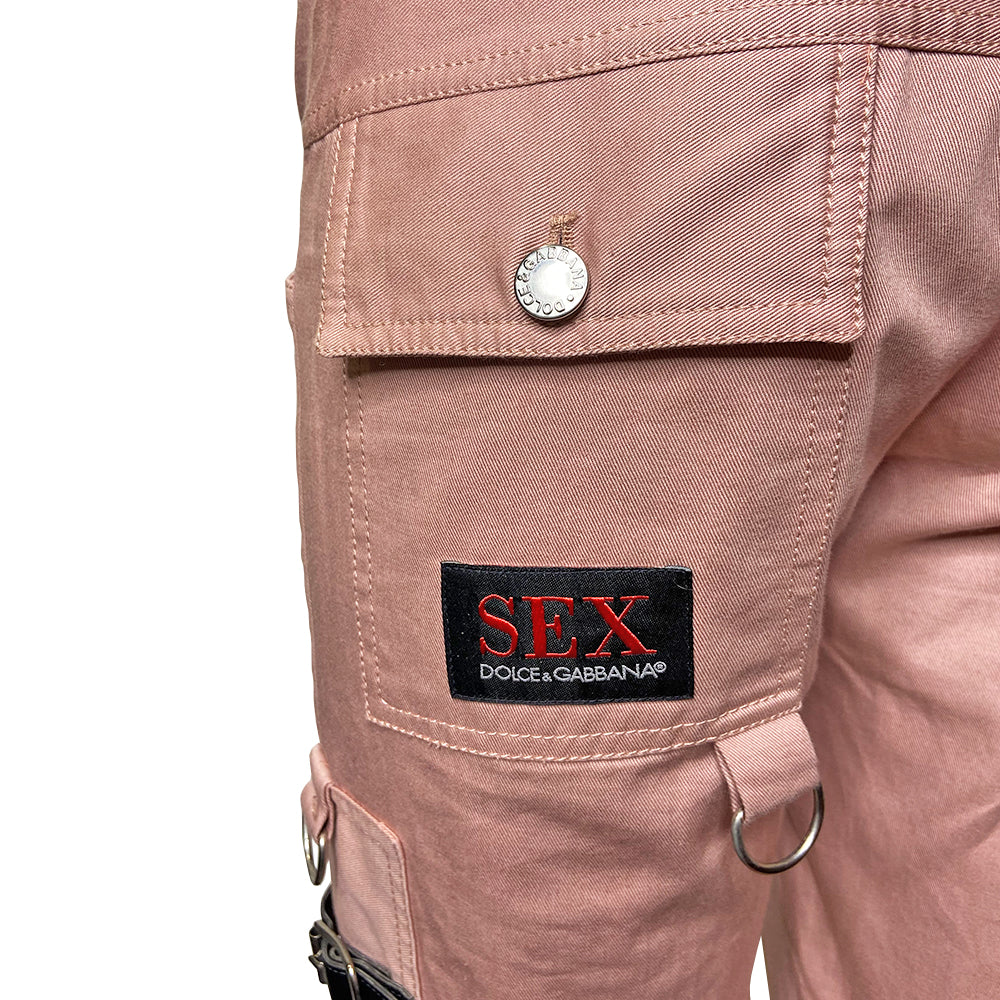 D&G pink Sex Bondage Strap Pants, SS 2003 SEX runway with 2 oversized front patch pockets, silver-tone hanging D rings. Side panels feature 4 black leather straps, logo engraved buckles, single adjustable fabric strap that wraps at knee. Cargo flap pocket in back with engraved silver-tone logo button, appliqué SEX logo patch. Made in Italy 