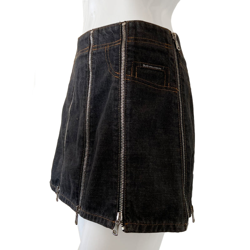 Dolce & Gabbana Zip Panel Black Denim Mini Skirt from 2004 with 10 zippered denim panels and silver-tone D&G stamped zipper pulls that unzip individually from bottom to top.  Accent stitching to mimic jeans pockets in back and front. D&G tag attached to faux front pocket. Made in italy