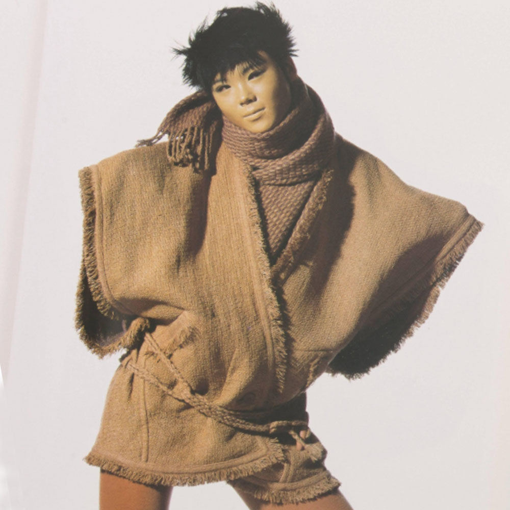  Fall 1984 Issey Miyake black fringed woven vest documented in Irving Penn's book, "Issey Miyake Photographs By Irving Penn", page 32 with back ornament detail featuring beads, sequins and embroidery with two side pockets, rope belt toggle tie, single front button. Style: NO ED67194. Made in Japan