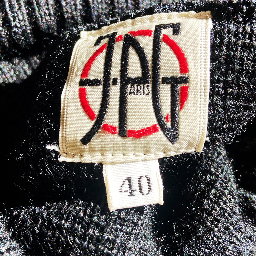 Jean Paul Gaultier cropped black wool turtleneck sweater circa 1990’s from JPG Paris label with with attached cape ribbed at neck and sleeve hems, JPG triangular logo at center chest. Made in Japan 