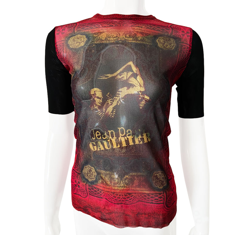 Jean Paul Gaultier tattoo artist 3/4 sleeve mesh top Jean Paul Gaultier Femme circa 1995 featuring Jean Paul Gaultier tattooing a woman’s arm on front and back. Tag size: 40 Main Colors: Red, black sleeves. Made in Japan 