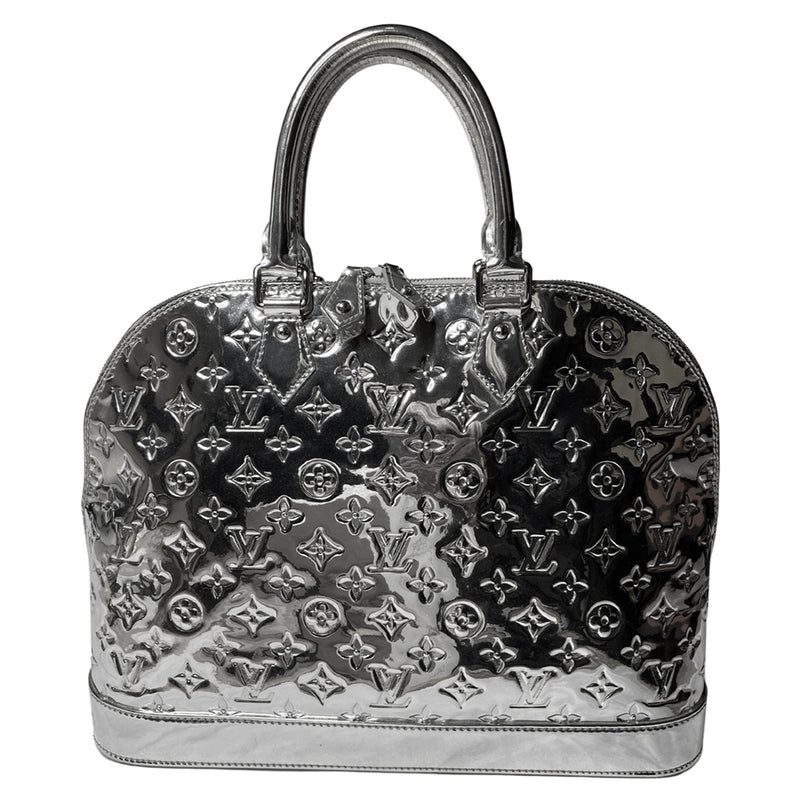 Louis Vuitton mirrored silver-tone monogram embossed vinyl Alma GM bag by Marc Jacobs for Louis Vuitton, 2008 with mirrored silver-tone leather dual handles, trim, bottom with tonal metal feet. Silver-tone top zipper with dual mirrored leather zipper pulls, grey textile interior with open slip and cell phone pocket. Made in France 