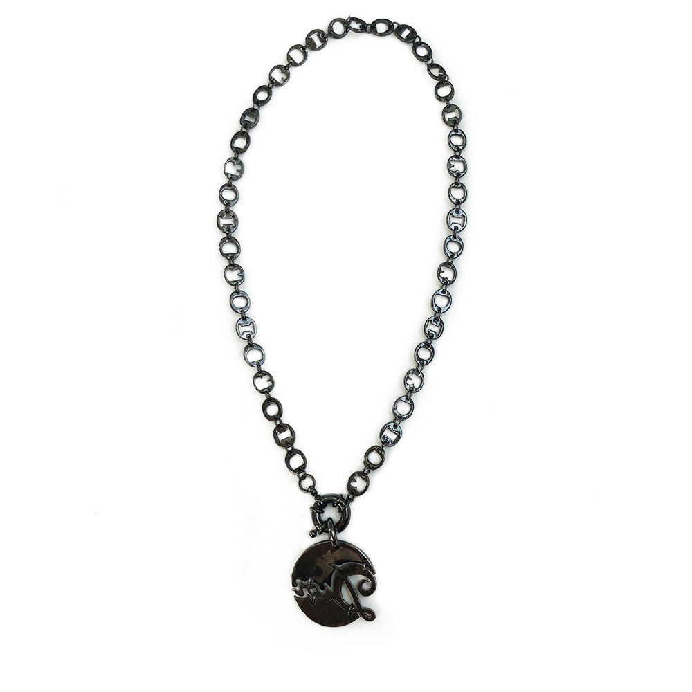 Christian Dior graphite-tone charm necklace. 9.25” chain links spell DIOR. Graphite tone crystals surround Dior signature pendant with front toggle clasp. 