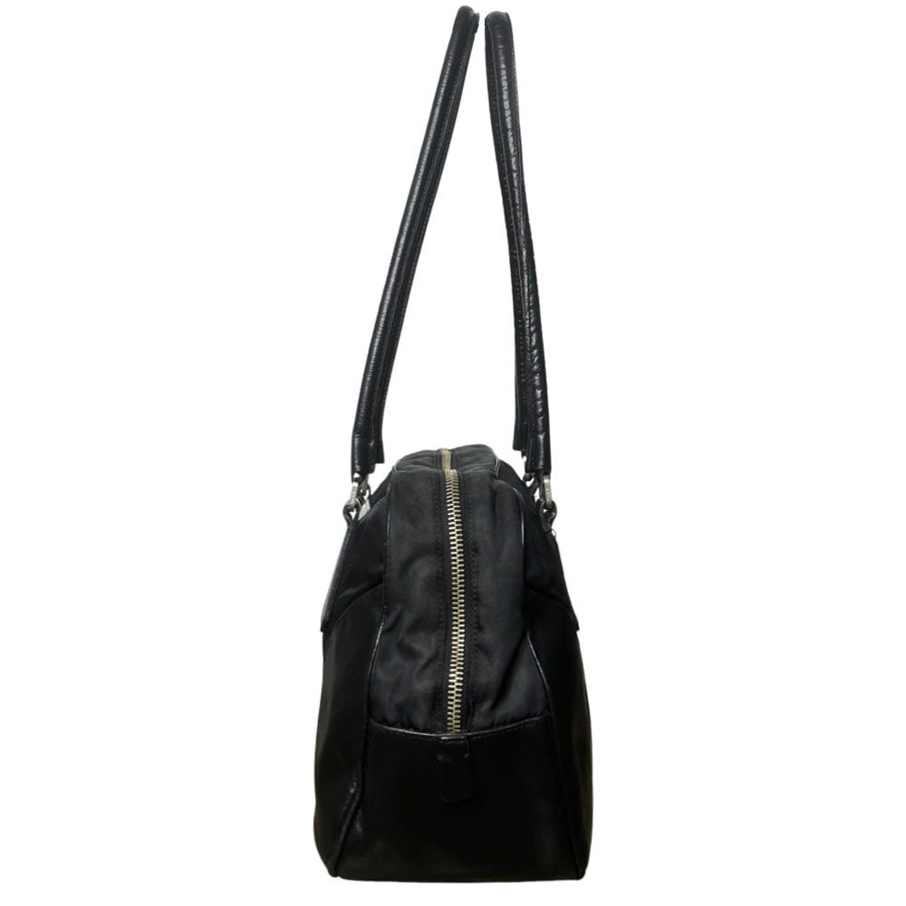 Prada tessuto Shoulder Bag Circa 2000's, black nylon bag with leather handles, front panels and piping, front logo plaque. Zip closure with silver-tone YKK zipper pull opens to black jacquard logo lining, one interior pocket. Made in Italy 