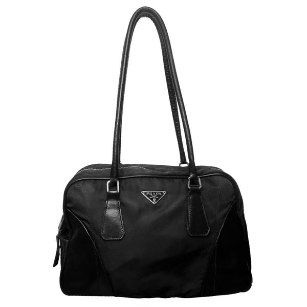 Prada tessuto Shoulder Bag Circa 2000's, black nylon bag with leather handles, front panels and piping, front logo plaque. Zip closure with silver-tone YKK zipper pull opens to black jacquard logo lining, one interior pocket. Made in Italy 