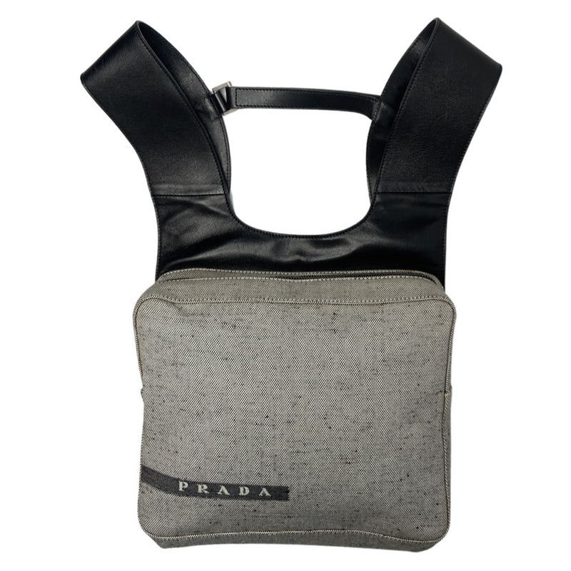 Prada spring 1999 RTW runway backpack in black and white tweed with black leather backing, adjustable leather harness straps, silver-tone hardware. Top zipper opens to jacquard logo textile lining with interior zip pocket. Made in Italy 