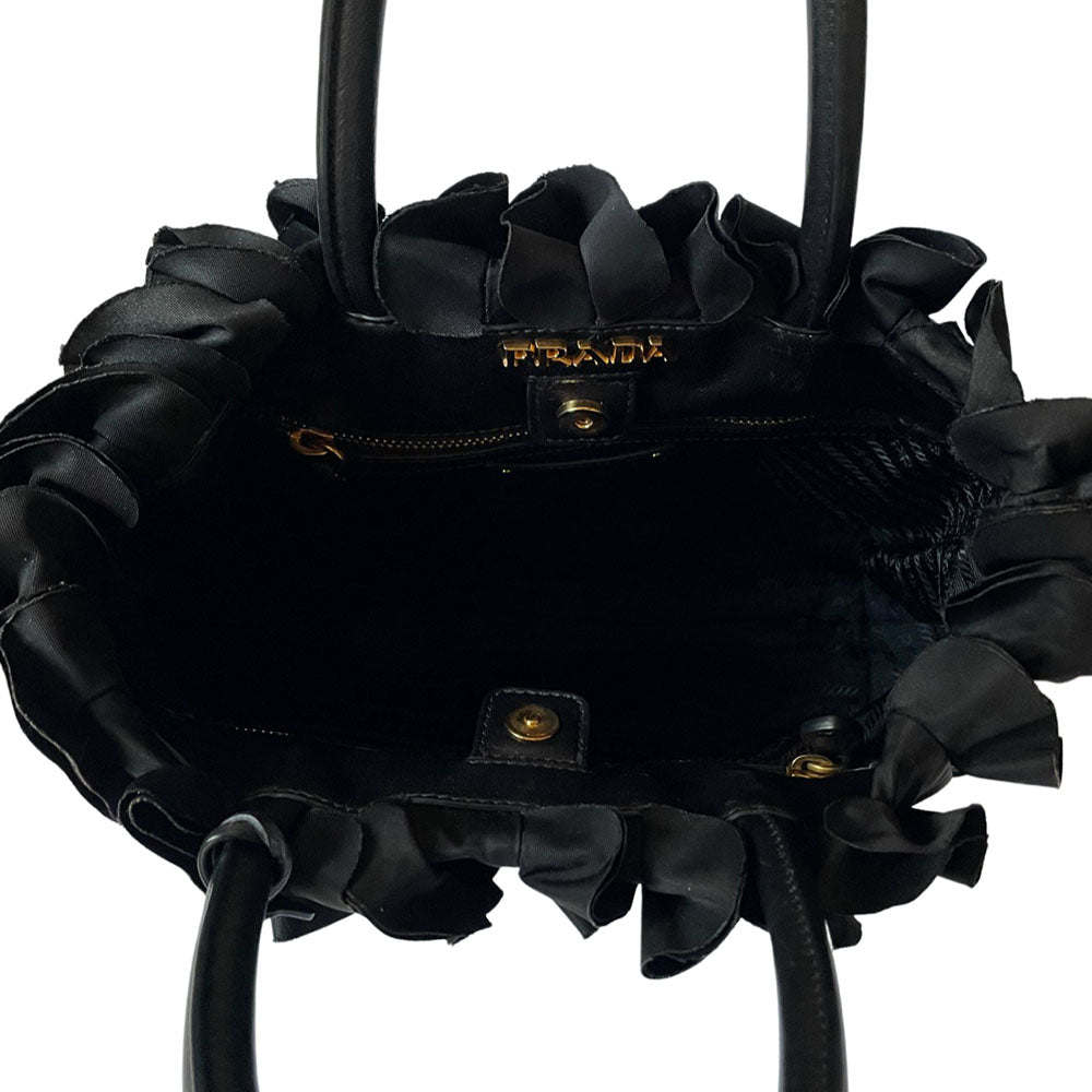 Prada 2000s black ruffled body tessuto nylon tote with leather handles, accent and hanging clochette key holder featuring gold-tone logo. Gold-tone hardware, interior logo, zippers and logo engraved feet. Magnetic snap closure, interior trademark leather label, 2 interior zip pockets, Prada logo lining. Made in Italy 