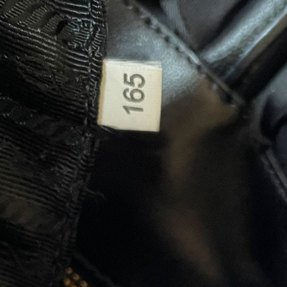 Prada 2000s black ruffled body tessuto nylon tote with leather handles, accent and hanging clochette key holder featuring gold-tone logo. Gold-tone hardware, interior logo, zippers and logo engraved feet. Magnetic snap closure, interior trademark leather label, 2 interior zip pockets, Prada logo lining. Made in Italy 