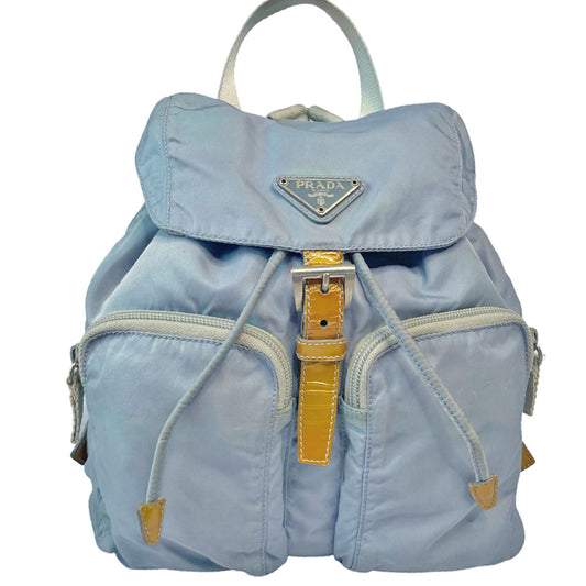 Prada powder blue nylon tessuto drawstring backpack circa 2011, magnetic closure flap with Prada logo plate, 2 zip outer front pockets, brown patent leather strap & accent, silver-tone Prada engraved buckle & drawstring grommets. Adjustable webbing & leather straps. Beige jacquard Prada logo textile lining with interior zip pocket. Made in Italy 