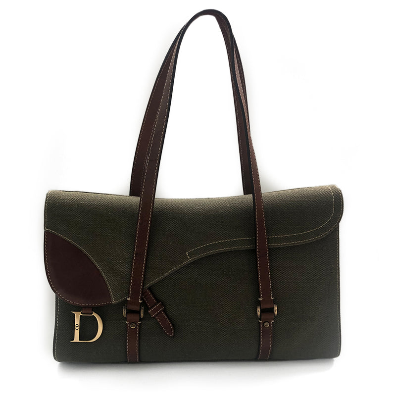 Christian Dior Canvas Saddle Tote by John Galliano.  Olive canvas with brown leather  handles and sides with front hanging brass logo D, accent stitching throughout. CD stamped brass-tone studs and links. Magnetic button closure. Brown Dior logo satin lining, suede and leather detail and side panels, single zip interior pocket.  Brass-tone metal feet. 