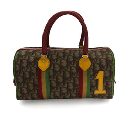 Christian Dior Rasta Boston Bag by John Galliano, 2003 beige and brown Diorissimo coated canvas, silver-tone hardware, vermillion leather rolled handles, yellow accent at base of handles. Yellow #1 front. Red, yellow and green canvas stripe on beige and brown Diorissimo print with bright green piping. Bottom domed silver-tone feet, single interior zip pocket and zip closure at top Vermillion textile interior, single zip pocket.