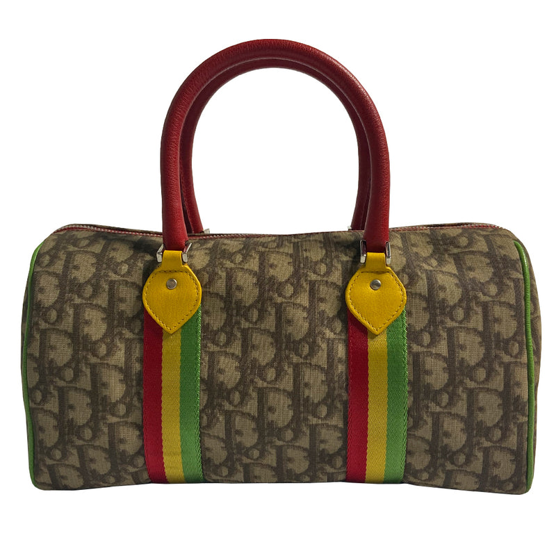 Christian Dior Rasta boston bag by John Galliano for Dior, 2004. Beige and light brown Diorissimo coated canvas with silver-tone hardware, 2 vermillion colored leather rolled top handles, yellow accent leather at base of handles. Yellow leather No 1 in front with red, yellow and green canvas stripe, green piping. Vermillion textile lining with zip pocket, top zip closure. Made in Italy 