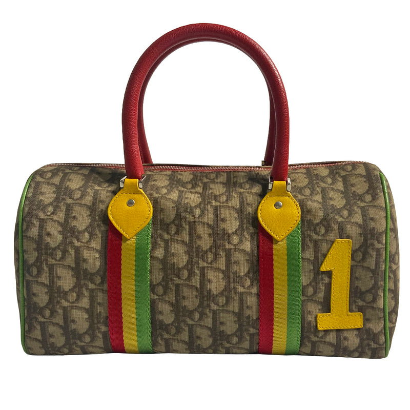 Christian Dior Rasta boston bag by John Galliano for Dior, 2004. Beige and light brown Diorissimo coated canvas with silver-tone hardware, 2 vermillion colored leather rolled top handles, yellow accent leather at base of handles. Yellow leather No 1 in front with red, yellow and green canvas stripe, green piping. Vermillion textile lining with zip pocket, top zip closure. Made in Italy 