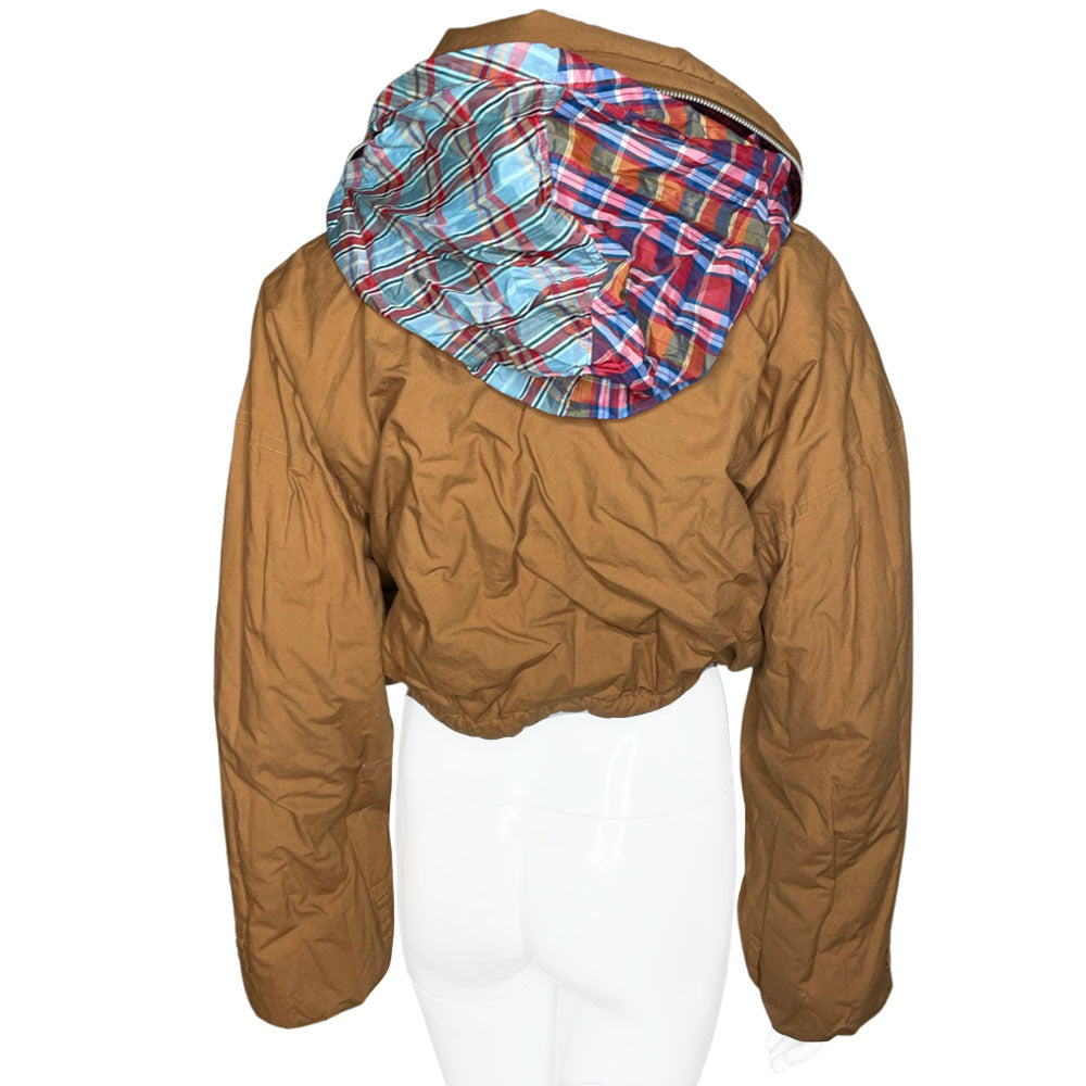 Tsumori Chisato long sleeved patchwork reversible hooded puffer jacket featuring a mix of madras & tartan fabrics with brown leather & canvas accent straps at wrists and pockets. Front zip closure with button, drawstring at waistline, puffy collar zips open to reveal hood. Reversible to all brown with zip-in tartan hood. Made in Japan 