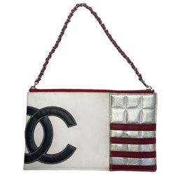 Chanel American Flag canvas and lamb leather pochette by Karl Lagerfeld for Chanel 2002/2003 with navy leather CC applique on white canvas, red leather stripes on quilted silver leather, canvas in back. Silver-tone hardware with woven leather and chain strap also acts as a zipper pull for top zip closure. Metallic silver foil vinyl lining. Made in Italy