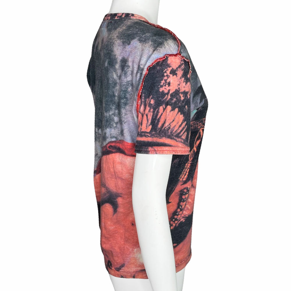 Short sleeve all-over printed tee featuring a man and woman in loving embrace Open neck tied with faux suede ties through silver-tone grommets, exposed seams at shoulders and side seams. Studded VP Logo on front lower left and crystal embellished velvet patch at shoulder. 